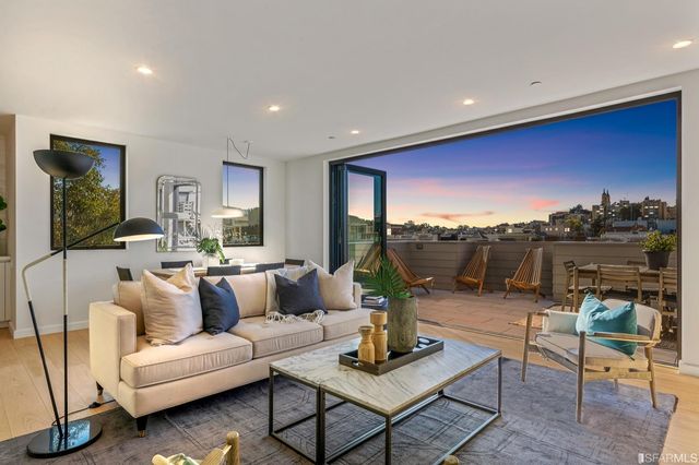a living room with furniture a rug and a floor to ceiling window