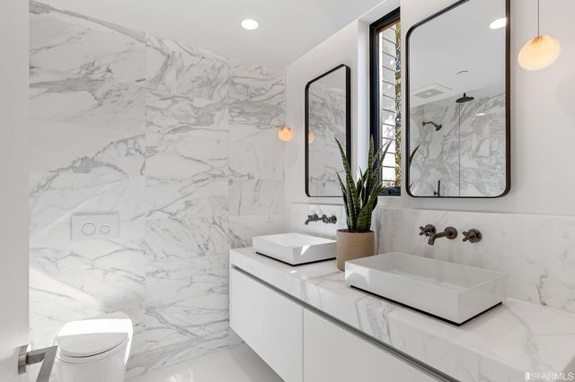 a bathroom with a granite countertop sink a toilet and mirror