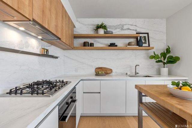 a kitchen with a sink a stove and cabinets