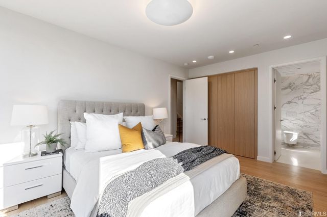 a bedroom with a large bed and wooden floor