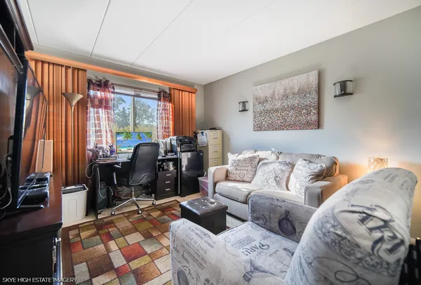 a living room with furniture a flat screen tv and a floor to ceiling window