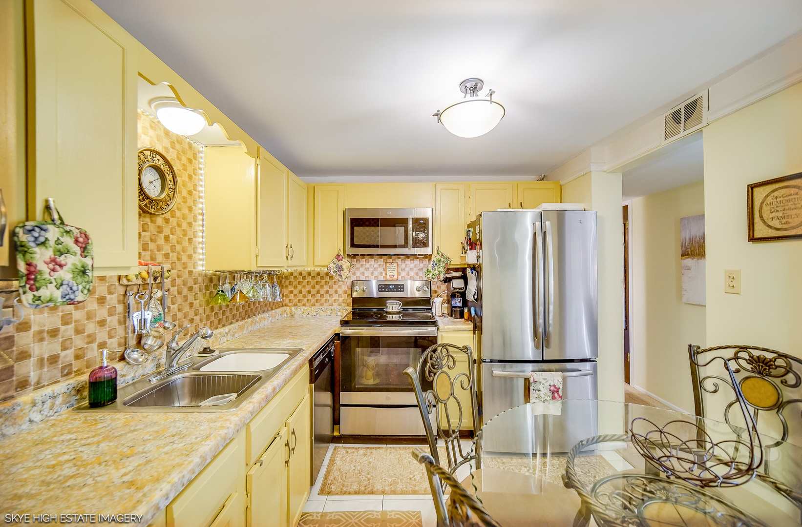 18855 Burnham Avenue, Unit 234 Lansing, IL 60438 - Photo 10 of 19 a kitchen with stainless steel appliances granite countertop a stove top oven a sink a dining table and chairs with wooden floor