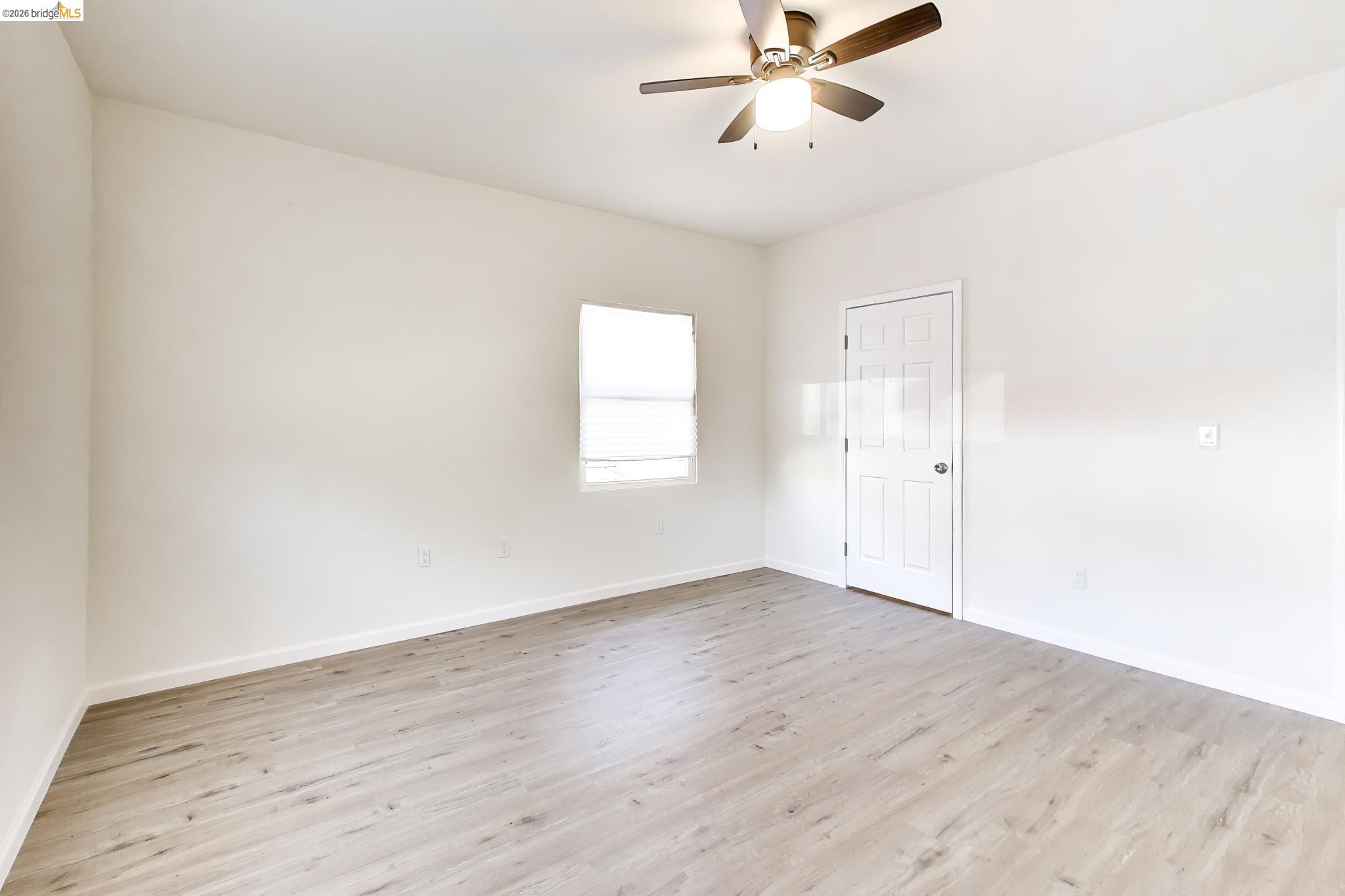 1978 Rosedale Avenue Oakland, CA 94601 - Photo 18 of 36 an empty room with wooden floor fan and windows