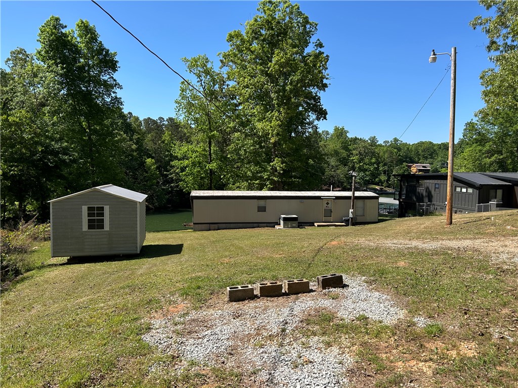 43 Sunset Cove Road Abbeville, SC 29620 - Photo 36 of 41 This property features multiple structures nestled among lush trees, offering a private and serene setting.