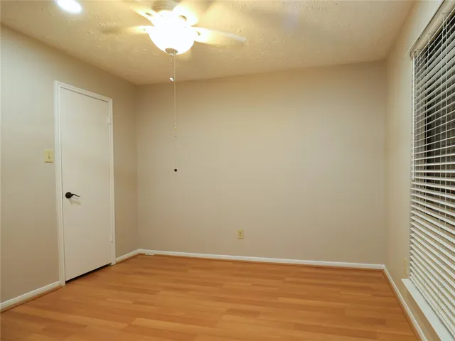 a view of a tennis ground with large trees