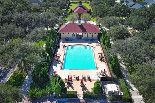 a view of swimming pool with lounge chair and dinning table under an umbrella