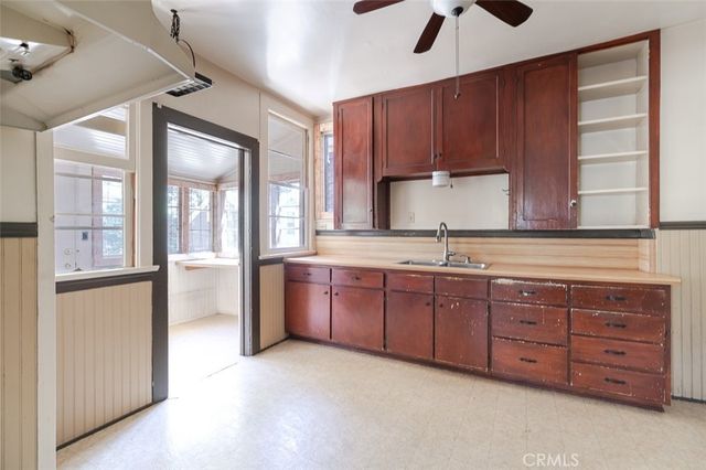 a kitchen with granite countertop wooden cabinets a sink a window and stainless steel appliances