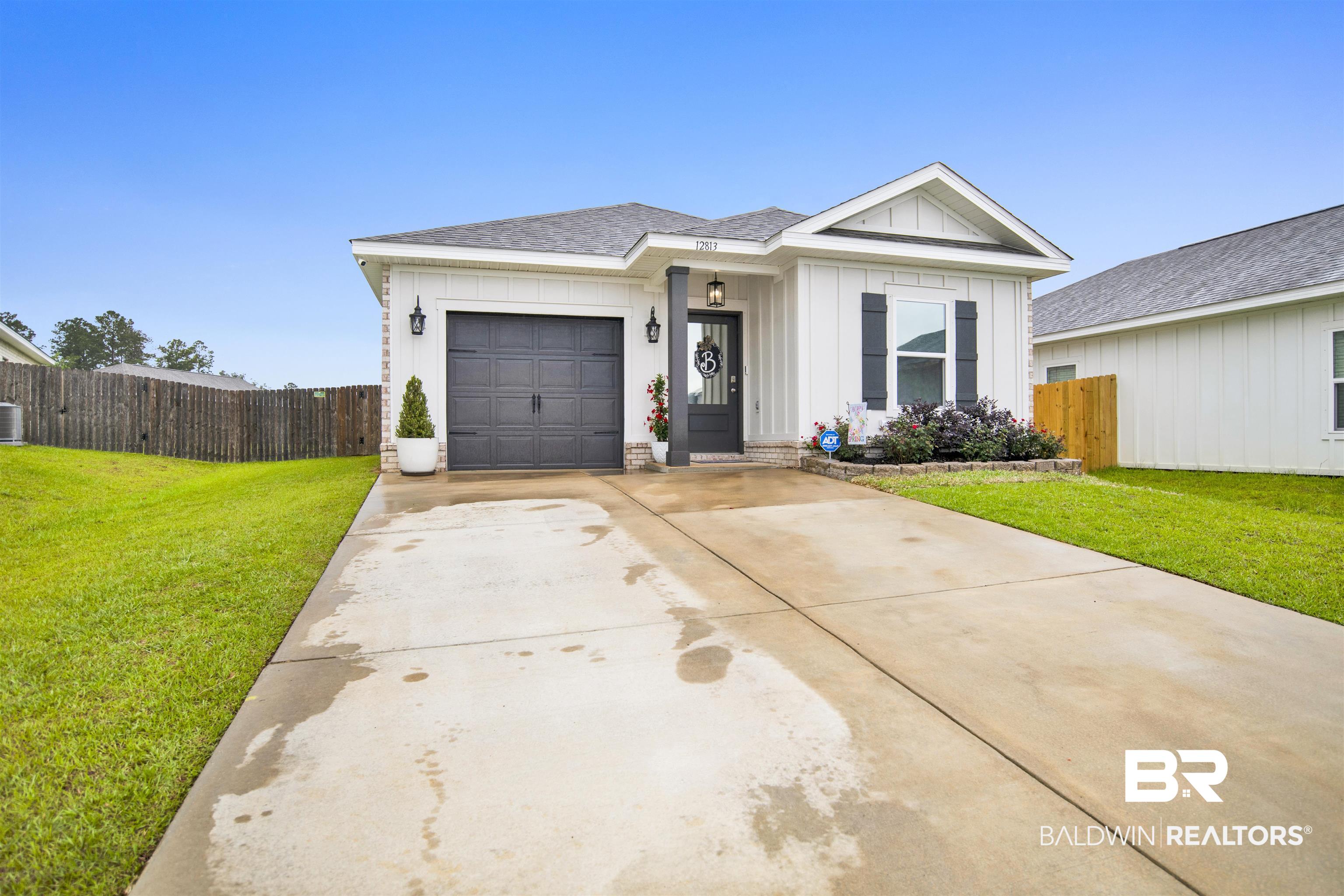 12813 Patriot Way Daphne, AL 36527 - Photo 23 of 23 Modern white siding exterior with a dark gray garage door, covered entry, and black window shutters