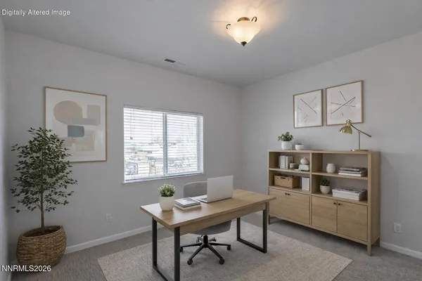 a view of a workspace with furniture and a window