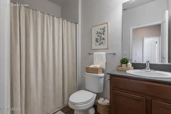 a bathroom with a granite countertop toilet and a sink