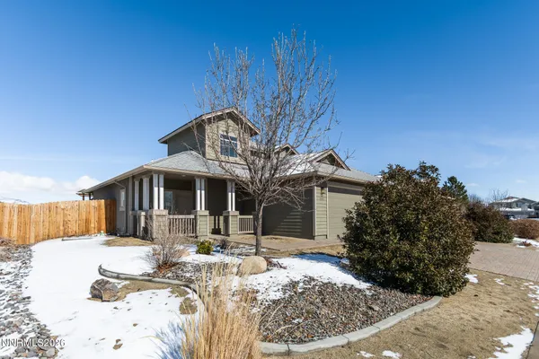 a front view of house with yard covered in snow