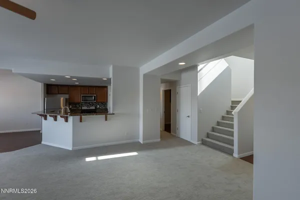 an empty room with windows and chandelier fan