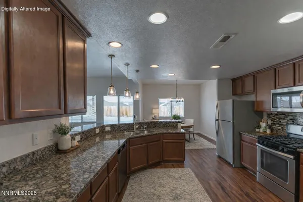 a large kitchen with granite countertop a stove sink and refrigerator
