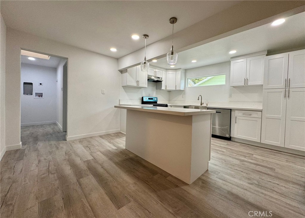 1362 South Downey Road Los Angeles, CA 90023 - Photo 12 of 30 a kitchen with stainless steel appliances granite countertop a sink stove and wooden floor