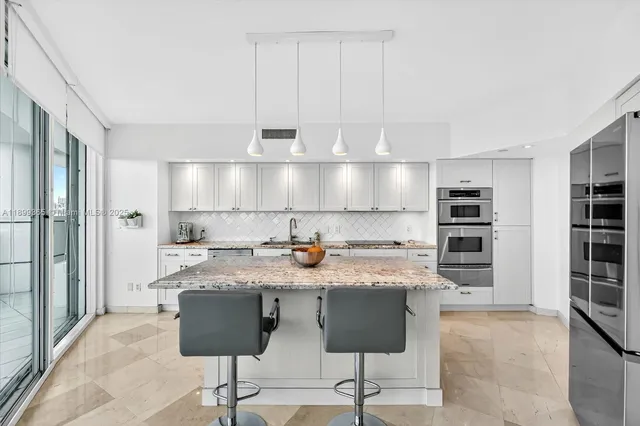 a kitchen with stainless steel appliances granite countertop a stove a sink and a refrigerator