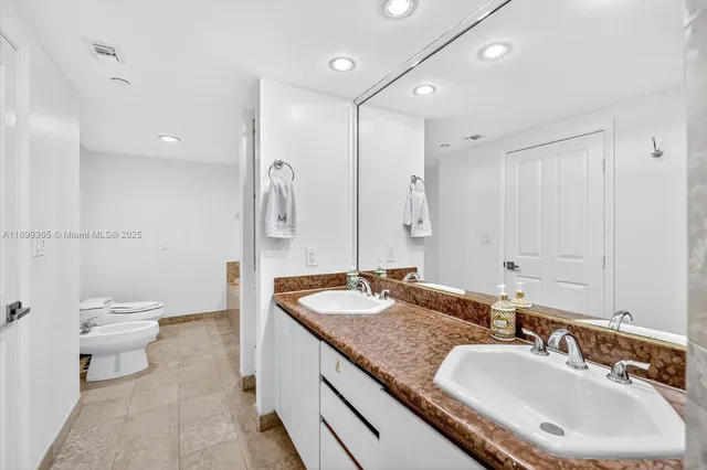 a bathroom with a granite countertop double vanity sink and a mirror