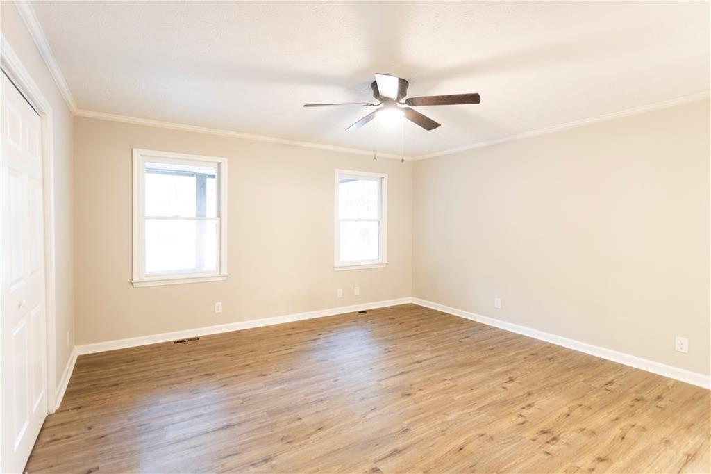 1149 Criswell Road Southeast Monroe, GA 30655 - Photo 12 of 60 a view of an empty room with wooden floor and a window