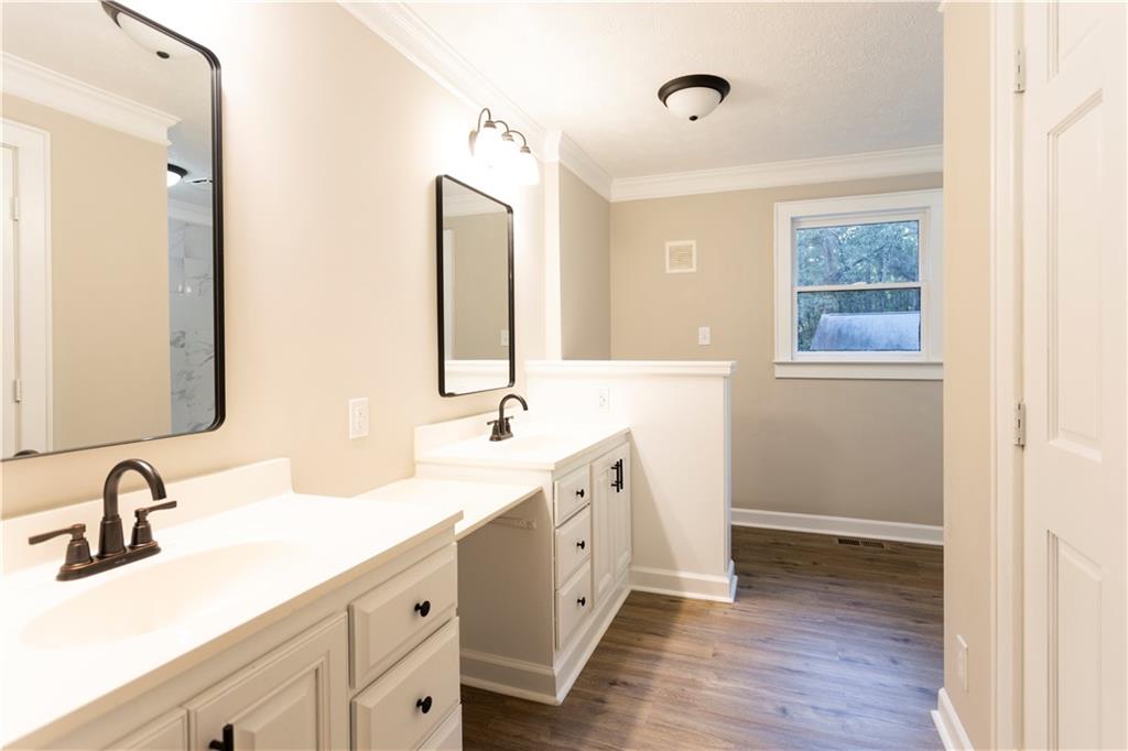 1149 Criswell Road Southeast Monroe, GA 30655 - Photo 15 of 60 a bathroom with a double vanity sink and mirror