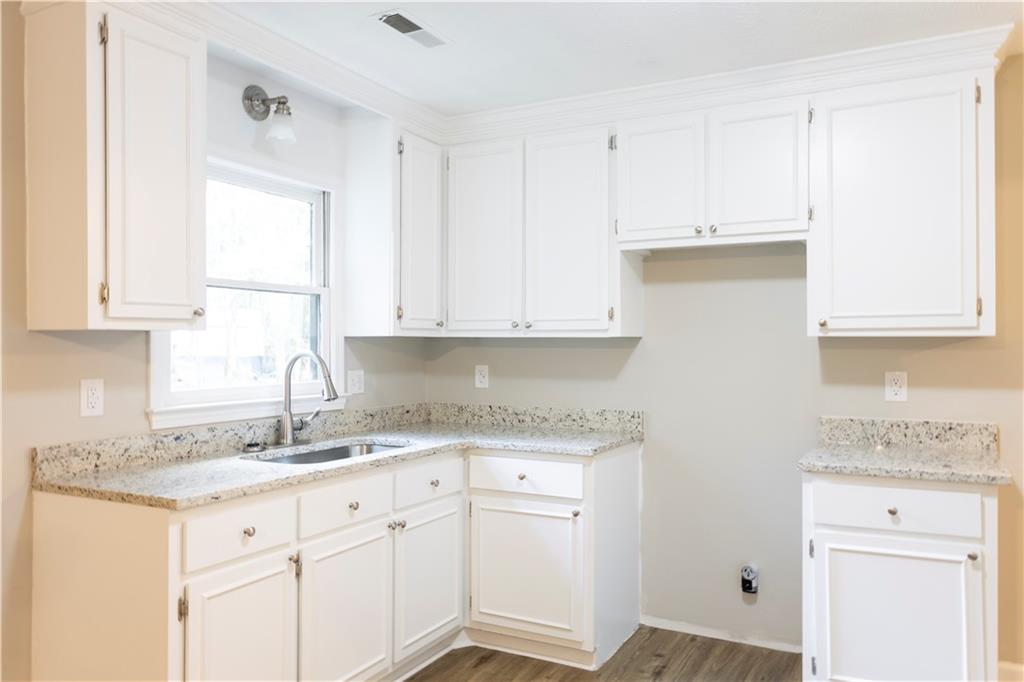 1149 Criswell Road Southeast Monroe, GA 30655 - Photo 19 of 60 a kitchen with granite countertop white cabinets white appliances and a sink
