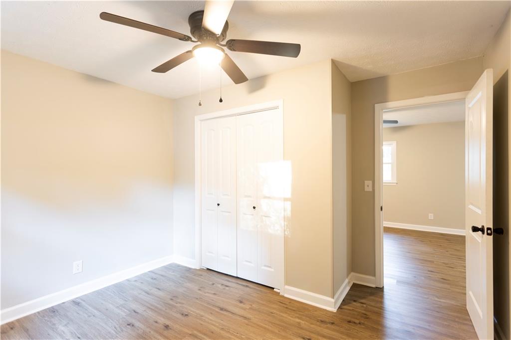 1149 Criswell Road Southeast Monroe, GA 30655 - Photo 27 of 60 an empty room with wooden floor fan and windows