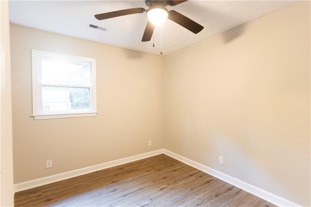 1149 Criswell Road Southeast Monroe, GA 30655 - Photo 28 of 60 an empty room with wooden floor ceiling fan and window