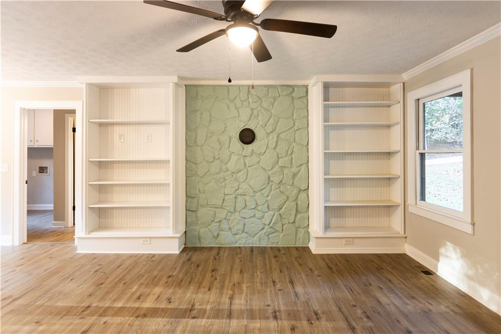 1149 Criswell Road Southeast Monroe, GA 30655 - Photo 6 of 60 a view of an empty room with a window and wooden floor