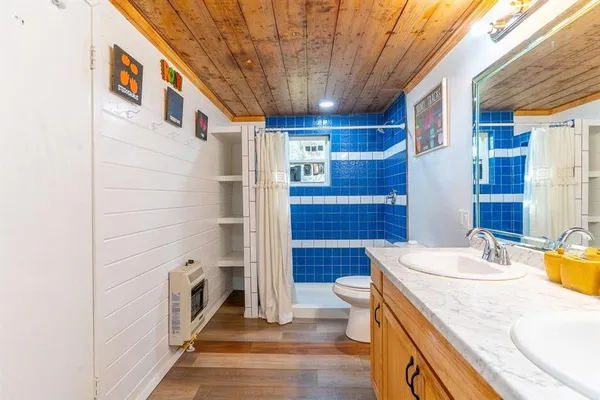 a bathroom with a sink a toilet and shower