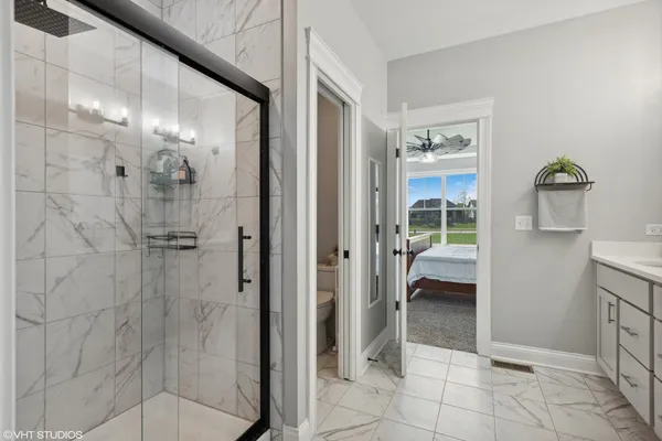 a bathroom with a glass shower door and a mirror