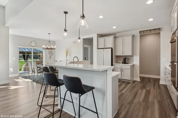 a kitchen with stainless steel appliances kitchen island granite countertop a stove a sink and a refrigerator