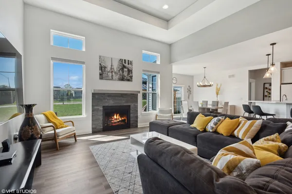 a living room with furniture a fireplace and a large window