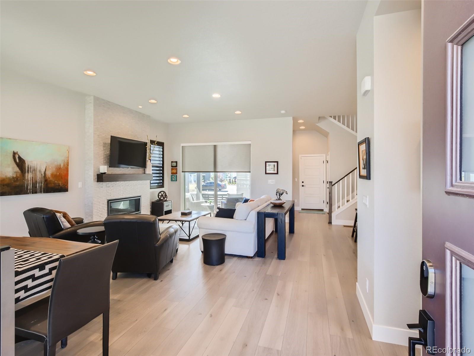 1602 Stablecross Drive Castle Pines, CO 80108 - Photo 4 of 28 a living room with fireplace furniture and a flat screen tv