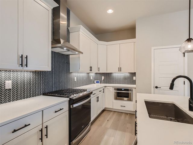 a kitchen with granite countertop a sink stove and cabinets
