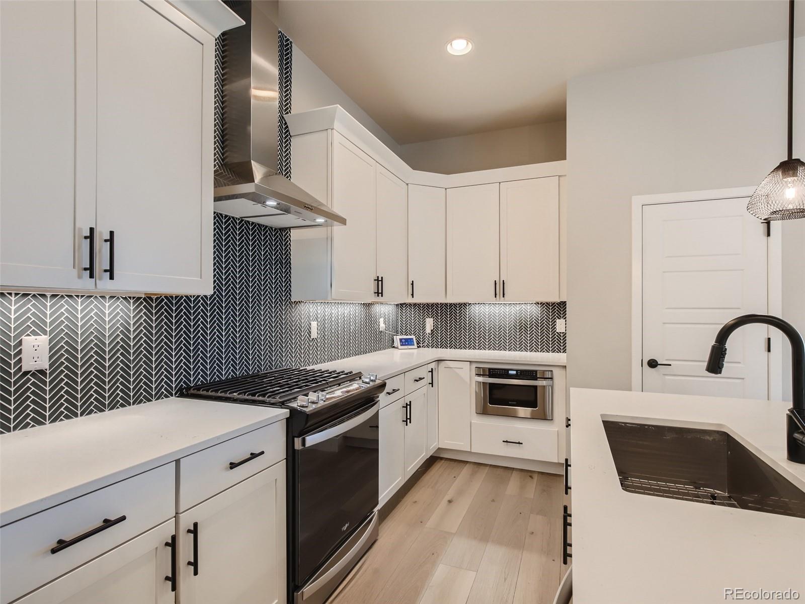1602 Stablecross Drive Castle Pines, CO 80108 - Photo 8 of 28 a kitchen with granite countertop a sink stove and cabinets