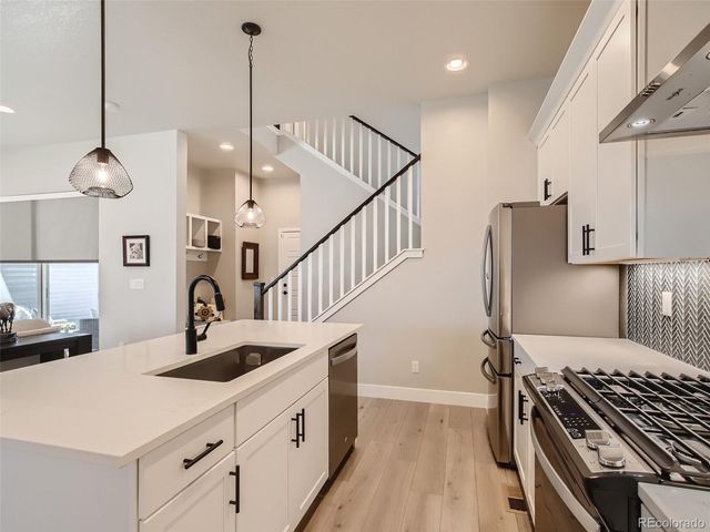a kitchen with kitchen island a sink and a stove with wooden floor