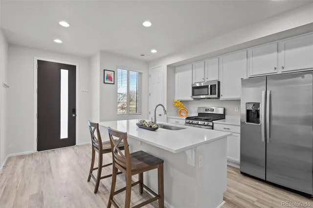 a kitchen with a table chairs refrigerator and microwave