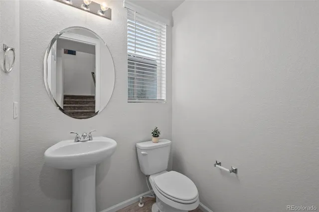 a bathroom with a toilet a sink and mirror