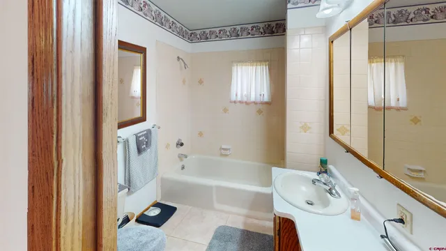 a bathroom with a tub sink and a mirror