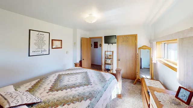 a bedroom with a bed and a dresser with rug