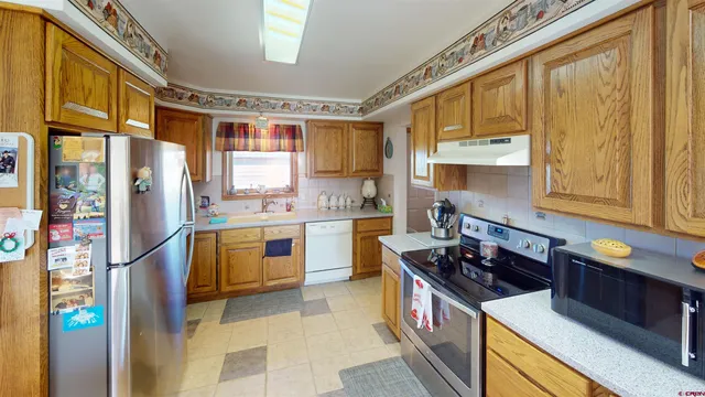 a kitchen with stainless steel appliances granite countertop a stove a sink and a refrigerator