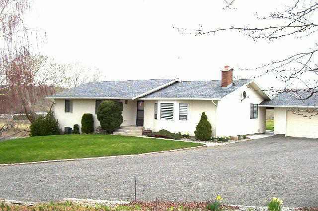 a view of a house with a yard and large tree
