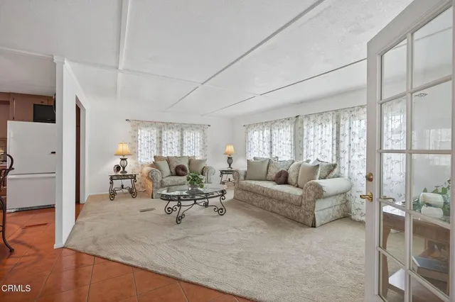 a living room with furniture large window and glass door
