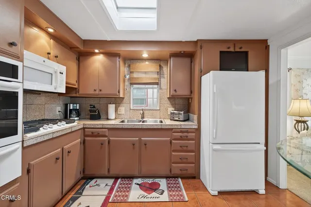 a kitchen with a refrigerator sink and cabinets