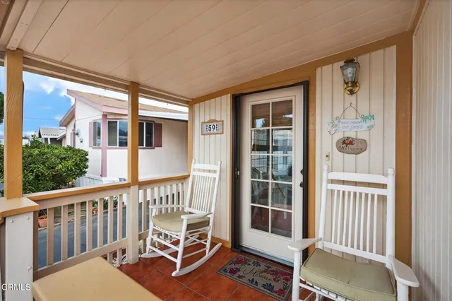 a porch with a bench next to a yard