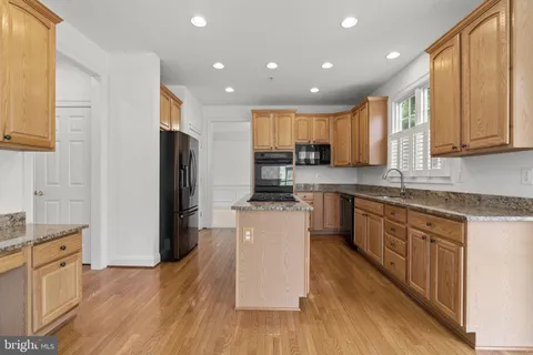 a view of kitchen with stainless steel appliances refrigerator stove microwave and cabinets