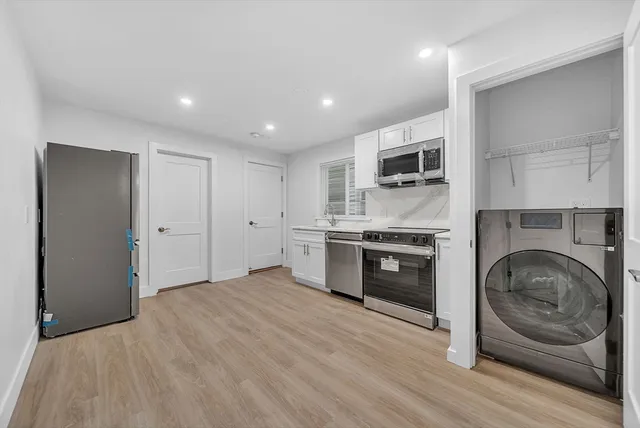 a kitchen with stainless steel appliances granite countertop a stove a sink and a refrigerator