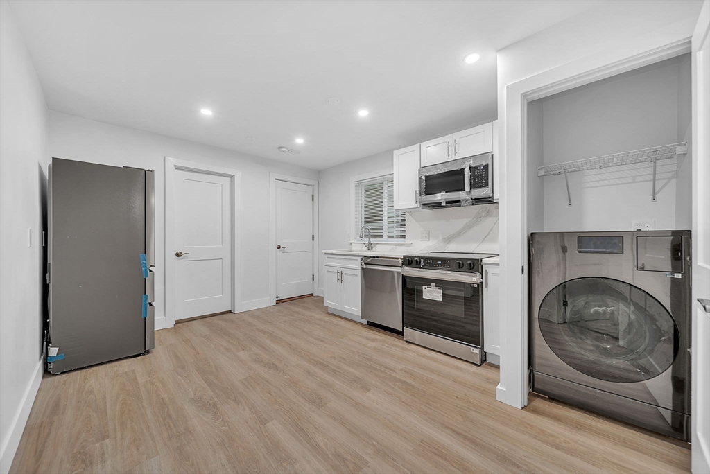 a kitchen with stainless steel appliances granite countertop a stove a sink and a refrigerator