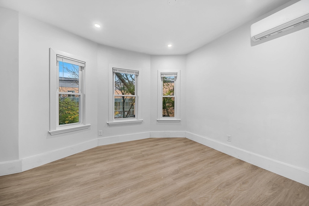 92 Willow Street, Unit 3 Cambridge, MA 02141 - Photo 11 of 17 an empty room with wooden floor and windows