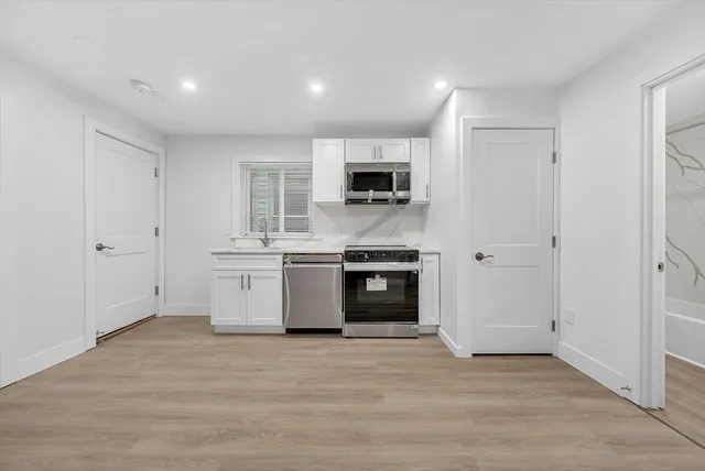 a view of kitchen with sink a microwave and refrigerator
