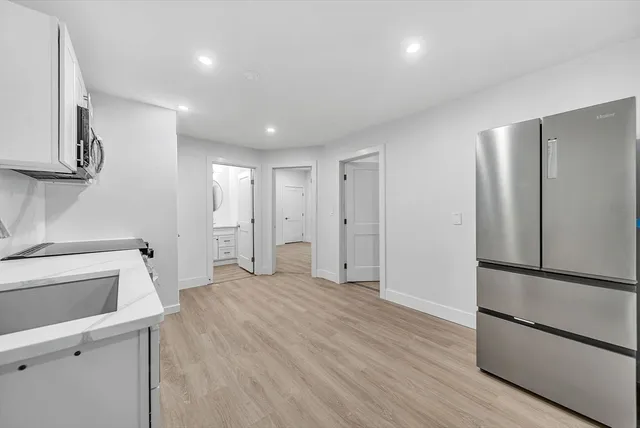 a view of a kitchen with a sink and a refrigerator