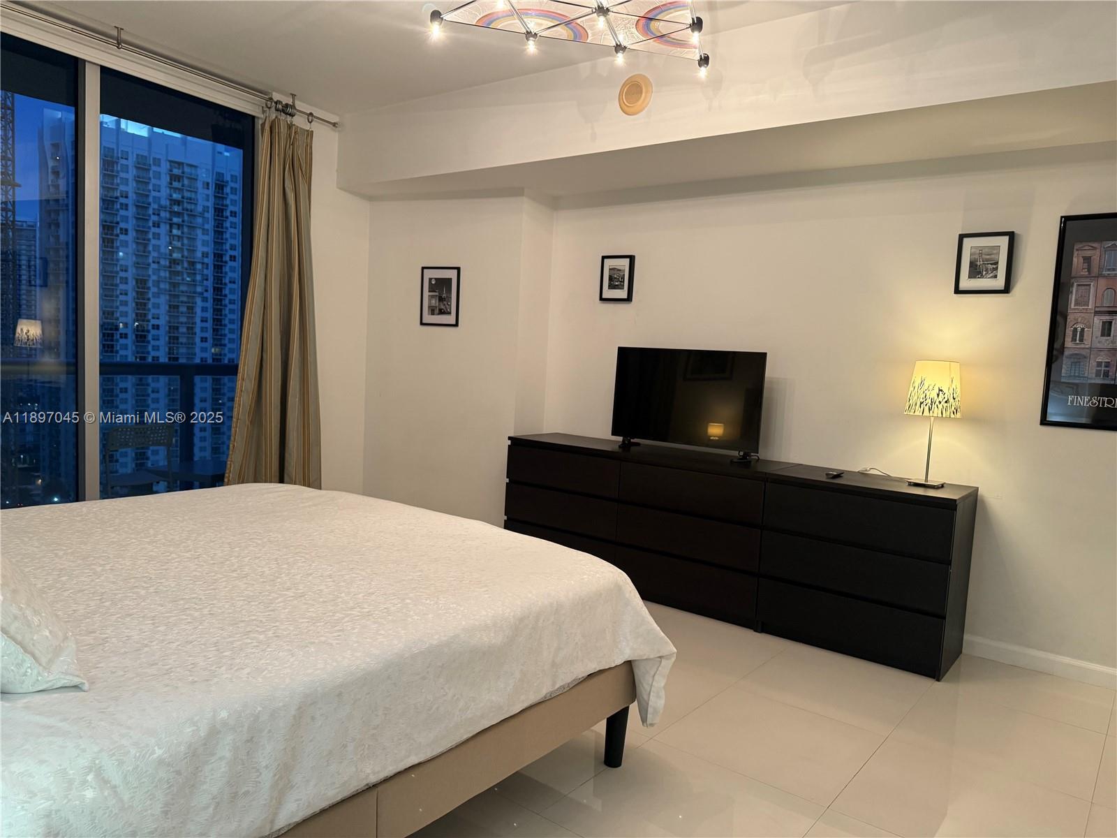 485 Brickell Avenue, Unit 2606 Miami, FL 33131 - Photo 17 of 18 a bedroom with a bed and a table